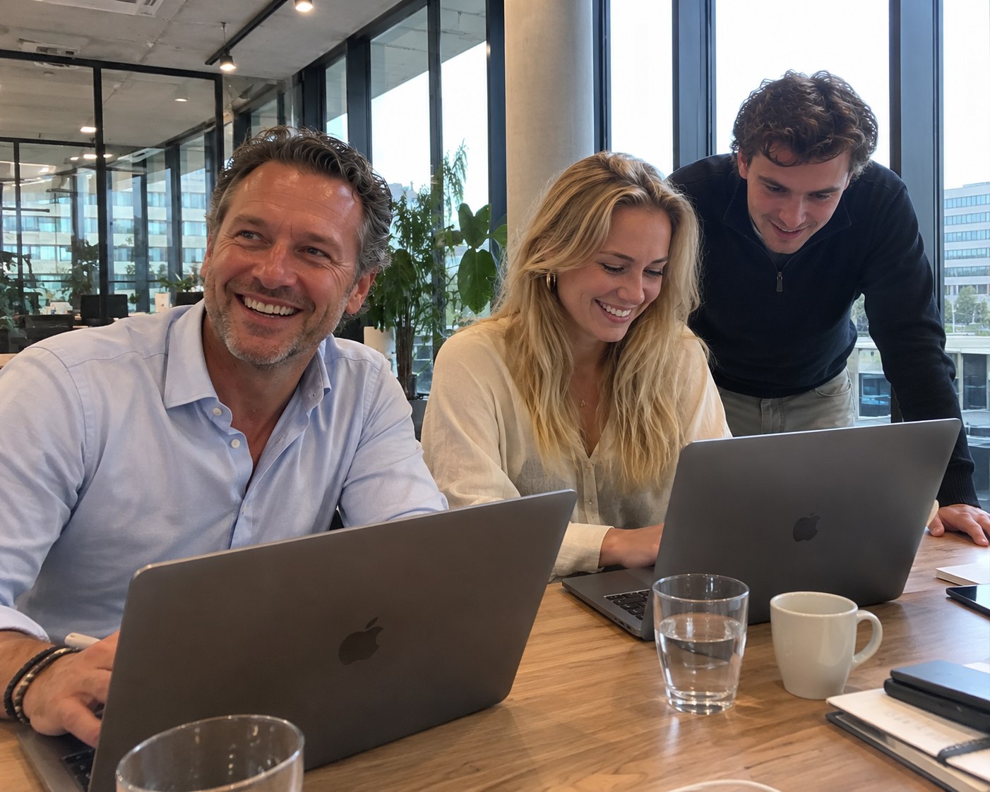Team aan het werk achter laptops in een modern kantoor